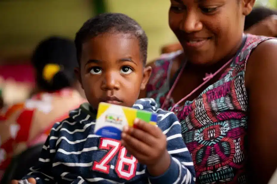 Família feliz usando celular para consultar benefício do Bolsa Família