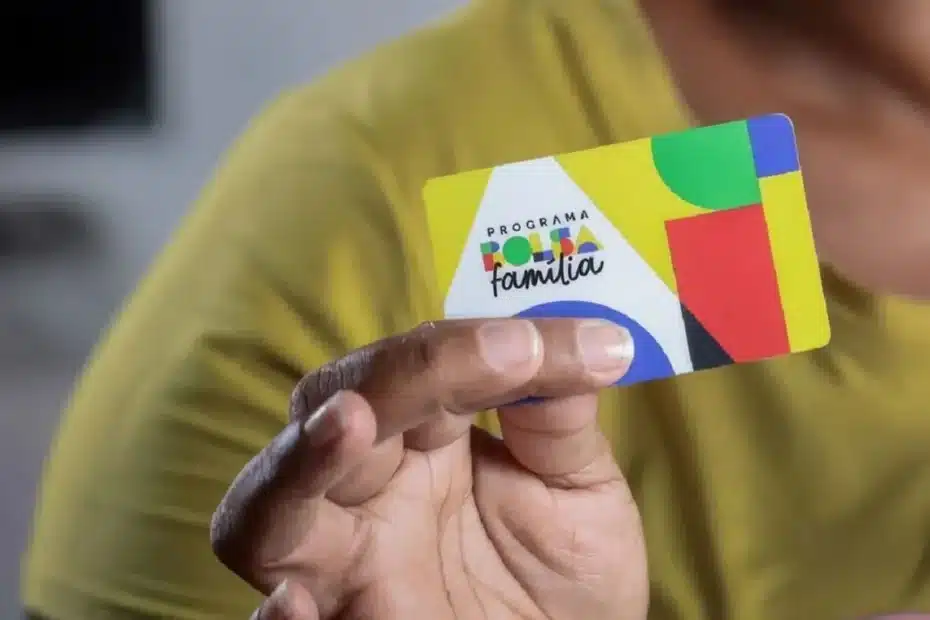 Família recebendo o cartão do Bolsa Família em um centro de assistência social