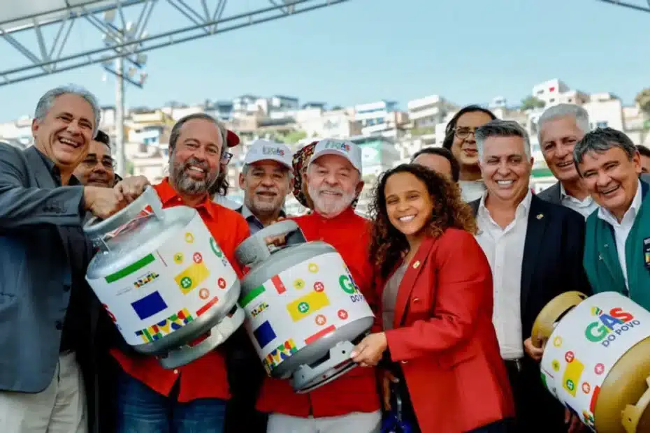 Mulher olha para botijão de gás vazio em casa humilde, preocupada com a falta do benefício.