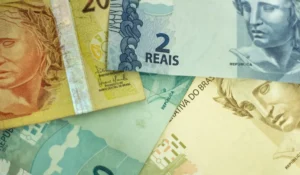 Mulher recebendo cartão do Bolsa Família em banco