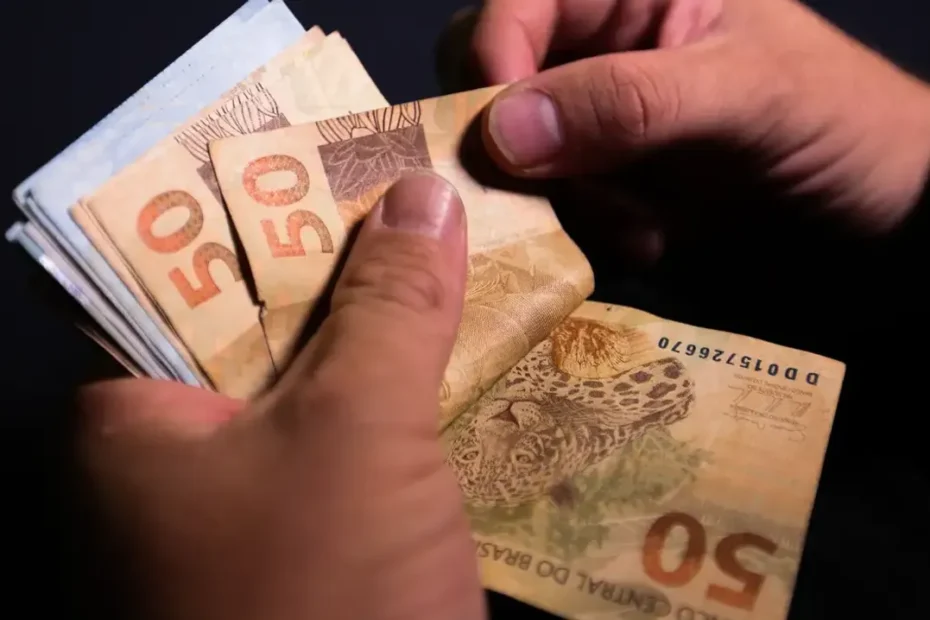 Trabalhador preocupado olha o holerite após anúncio de possível redução salarial por mudança na jornada de trabalho.