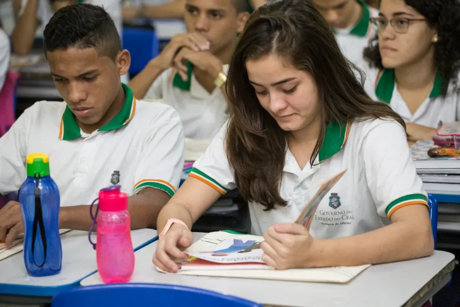 Estudantes brasileiros focados em um computador com informações sobre o Enem