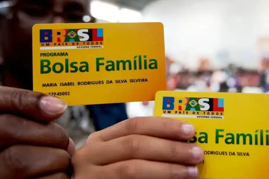 Mão de pessoa segurando válvula de botijão de gás, com cozinha desfocada ao fundo