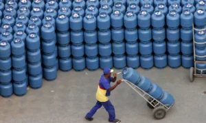 Mãe e filho em cozinha recebendo botijão de gás, simbolizando benefício do Gás do Povo
