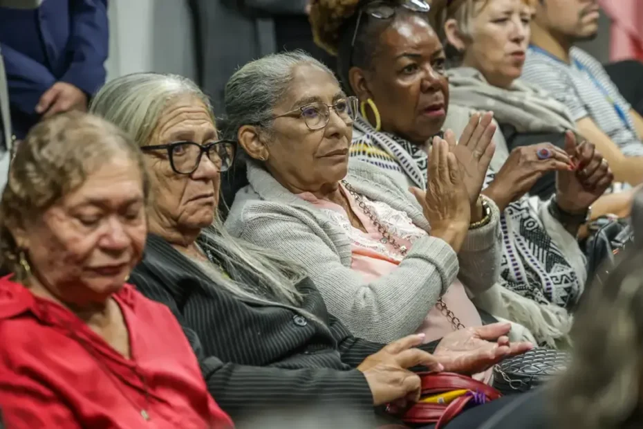 Idoso sorrindo ao verificar contas, indicando alívio financeiro