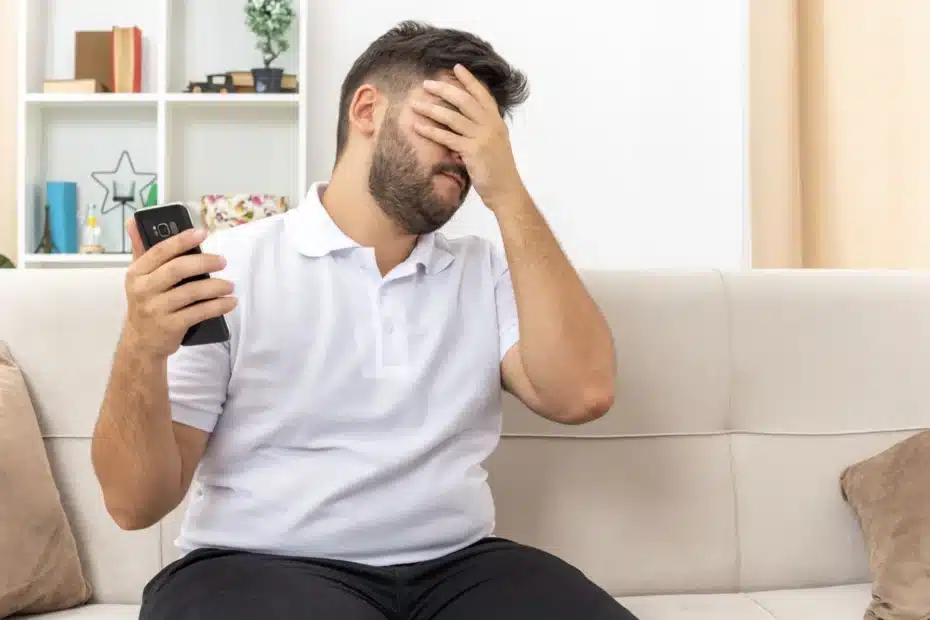 Pessoa checando aplicativo financeiro bloqueado no celular, simbolizando restrição a plataformas como Polymarket e Kalshi.