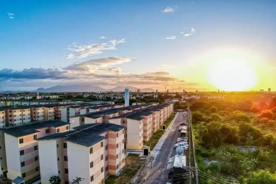 Família brasileira sorridente em frente à sua nova casa, simbolizando a conquista da moradia própria com o programa Minha Casa Minha Vida.