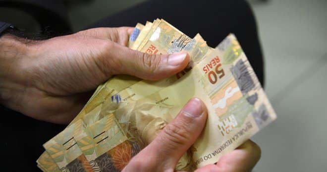Família alagoana em frente à sua casa recebe auxílio de programas sociais.
