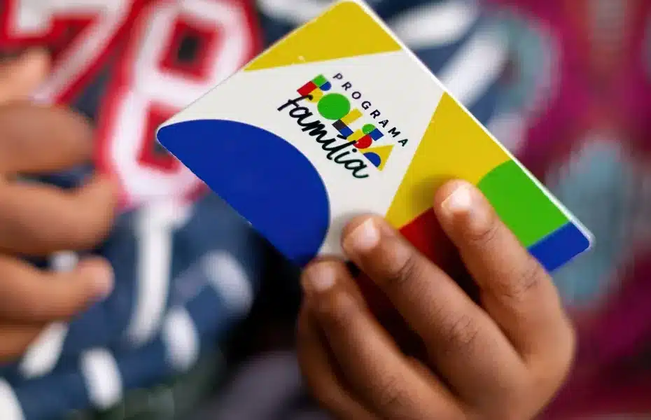 Mulher utilizando o aplicativo Bolsa Família no celular para consultar informações sobre o benefício.