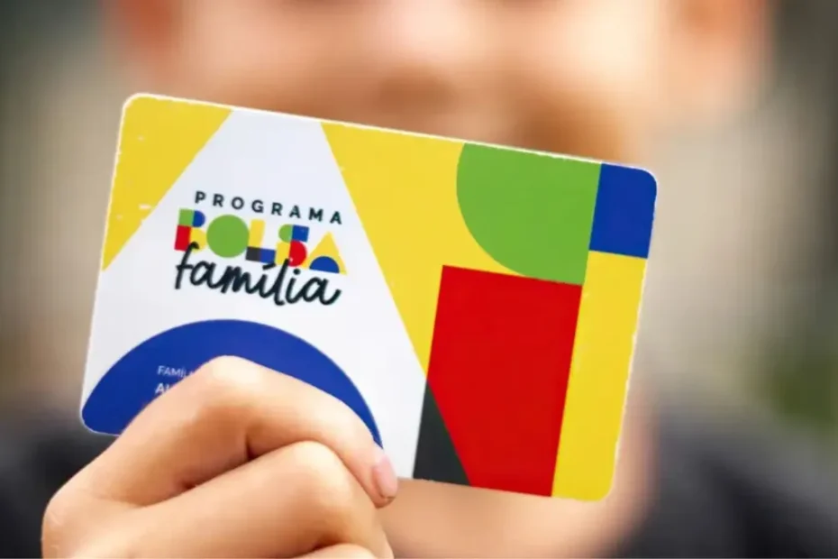 Mão segurando cartão do Bolsa Família com fundo de família