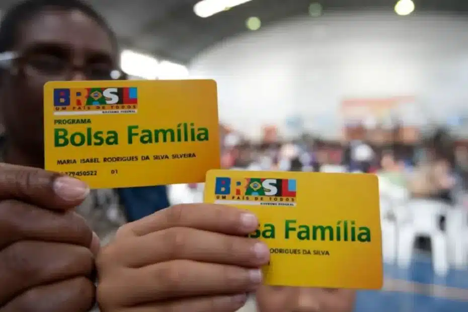 Pessoa olhando o celular com preocupação sobre o Bolsa Família bloqueado