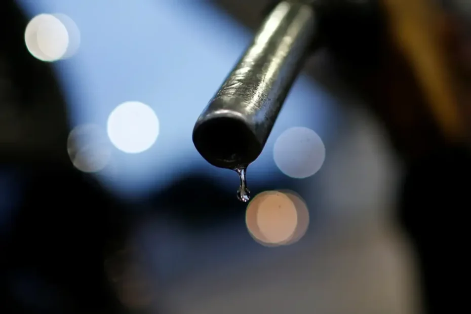 Pessoa preocupada com o preço da gasolina no posto, exibindo R$ 6,77 no marcador