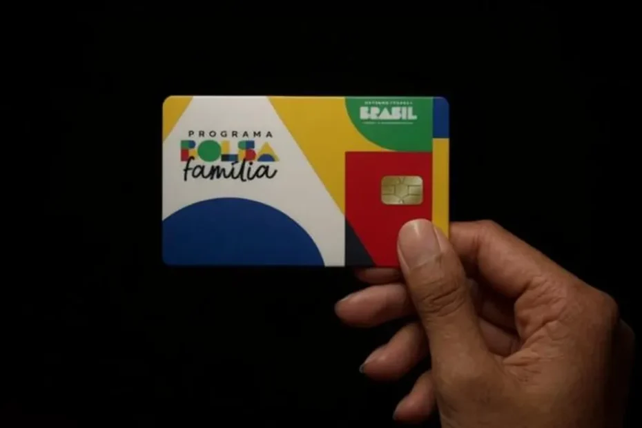 Mãe sorridente recebe cartão do Bolsa Família em centro de assistência