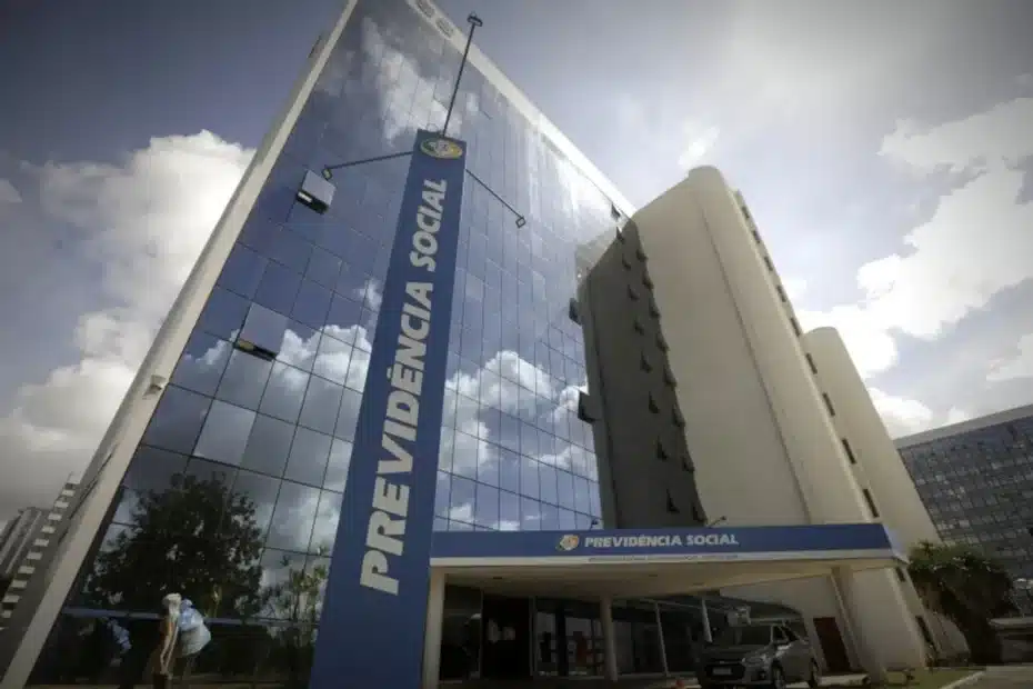 Servidor público do INSS analisando documentos em sua mesa.
