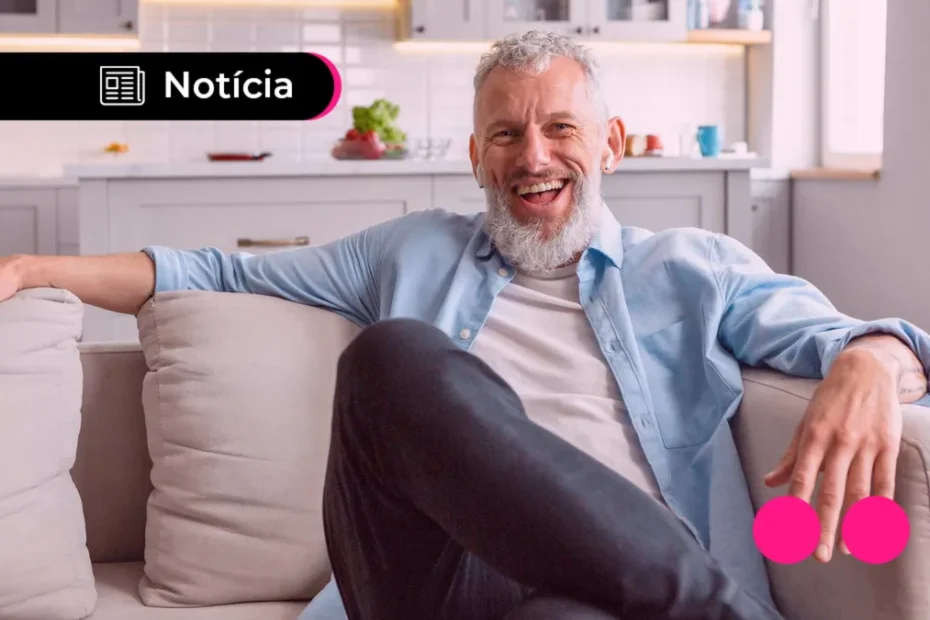 Aposentado do INSS sorri ao analisar informações financeiras em casa.