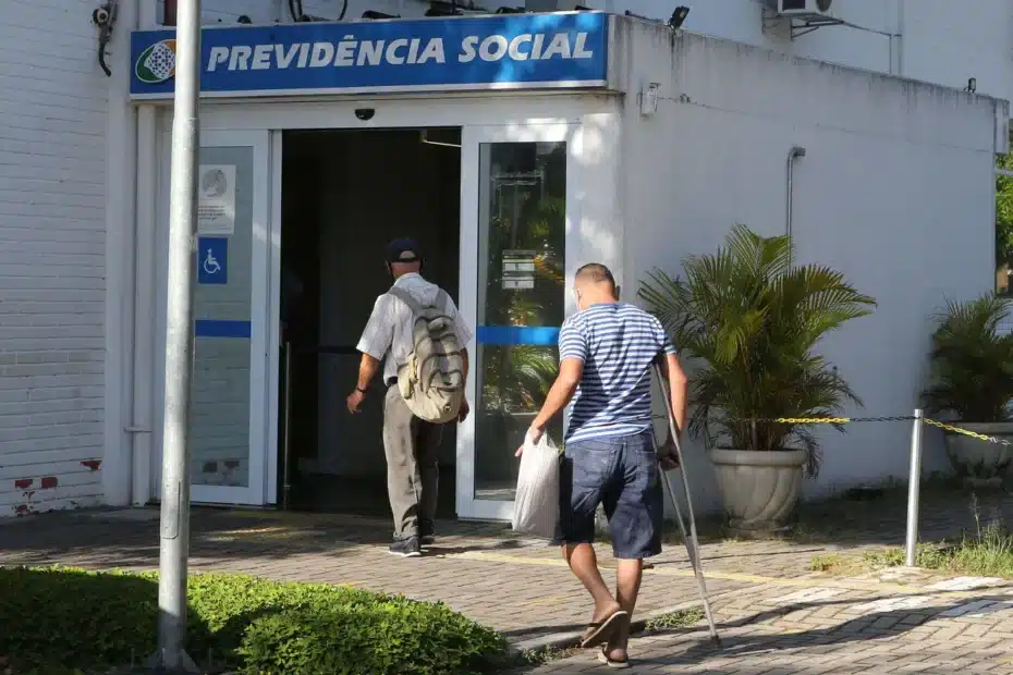 Fila de pessoas aguardando atendimento em frente a uma agência do INSS.