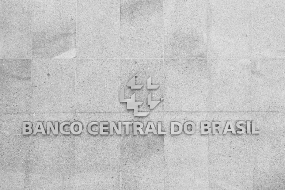 Mãos segurando um smartphone com transação de stablecoin e status de retenção no Brasil