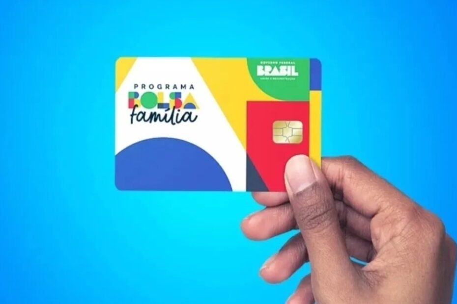 Cartão do programa Bolsa Família sendo segurado com foco no benefício social.