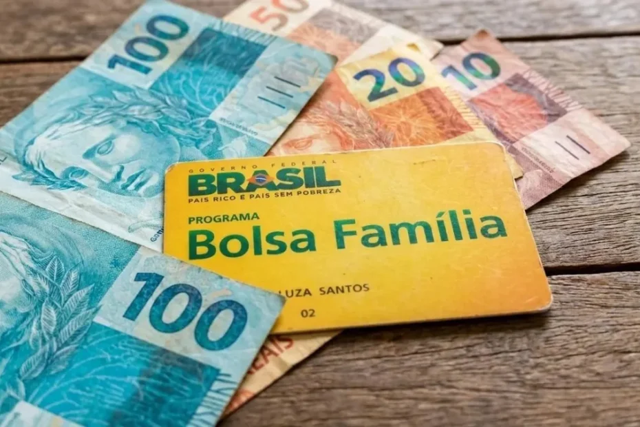 Mão de uma pessoa segurando um smartphone com aplicativo de apostas online bloqueado, simbolizando a restrição para beneficiários do Bolsa Família