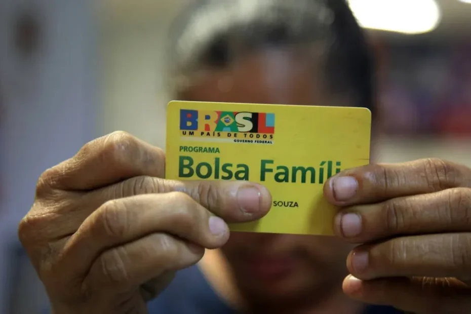 Mulher consulta informações sobre o Bolsa Família no celular, preocupada com o bloqueio do benefício.