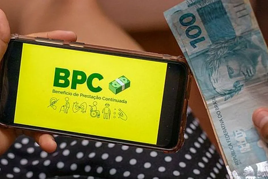 Mão de pessoa idosa consultando o calendário de pagamentos do INSS ou BPC/LOAS em um smartphone