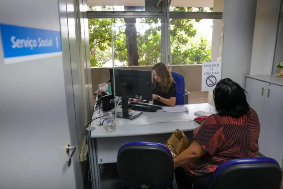 Pessoa segurando documentos em frente a uma agência do INSS.