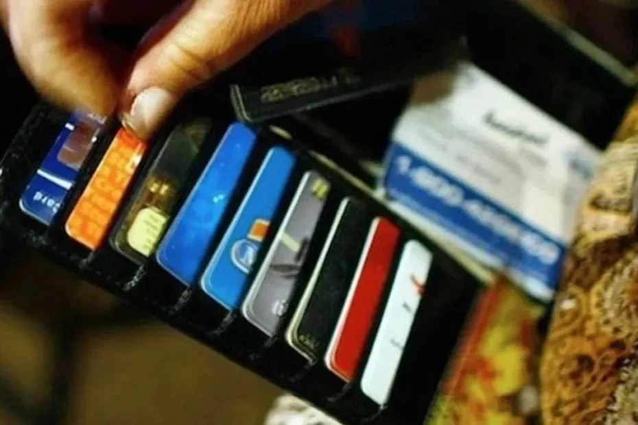 Pessoa preocupada analisando dados financeiros em um tablet, com contas e boletos na mesa, simbolizando a alta inadimplência e o endividamento familiar no Brasil.