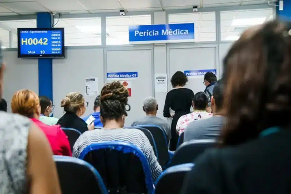 Mãos de uma pessoa preocupada segurando um celular com tela do INSS Atestmed e documentos médicos