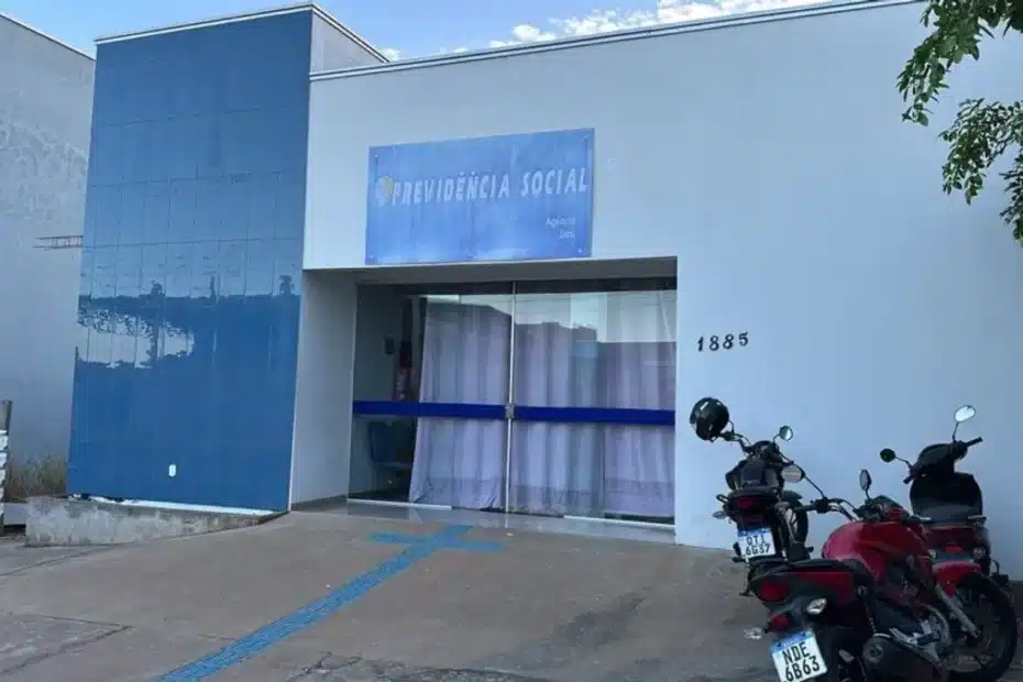 Documentos de assistência social e benefício do INSS sobre uma mesa de escritório.