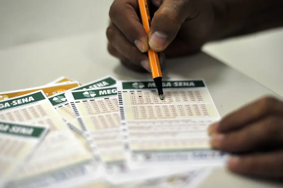 Notas de reais e um celular com aplicativo da Mega-Sena, representando a chance de ganhar o prêmio acumulado.