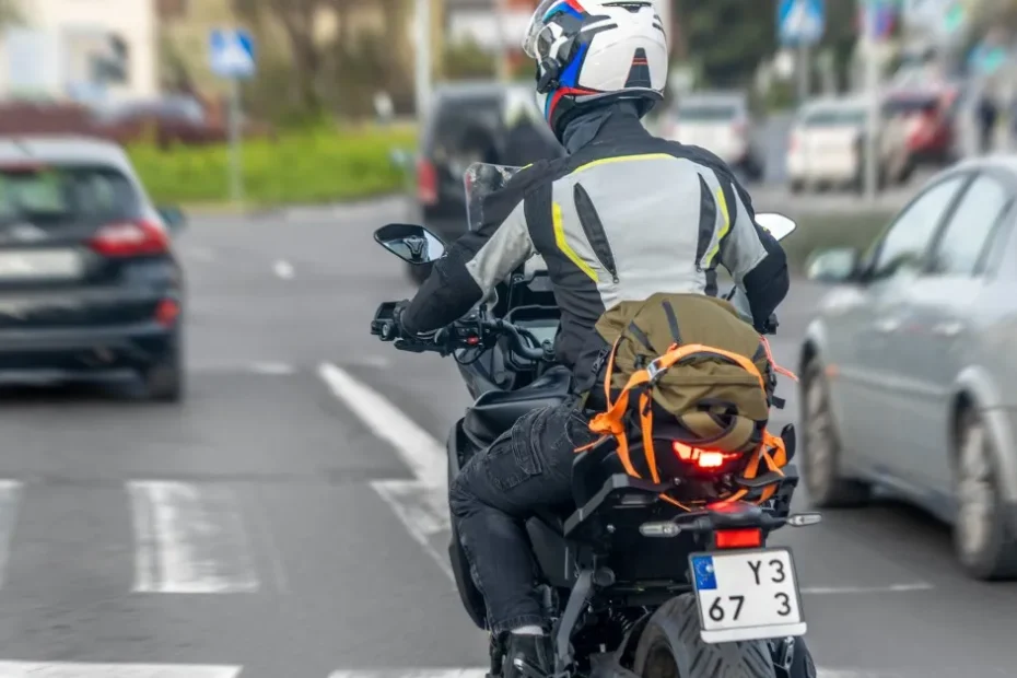 Mototaxista feliz em uniforme, segurando documentos de compra de uma motocicleta nova, simbolizando acesso a benefícios.