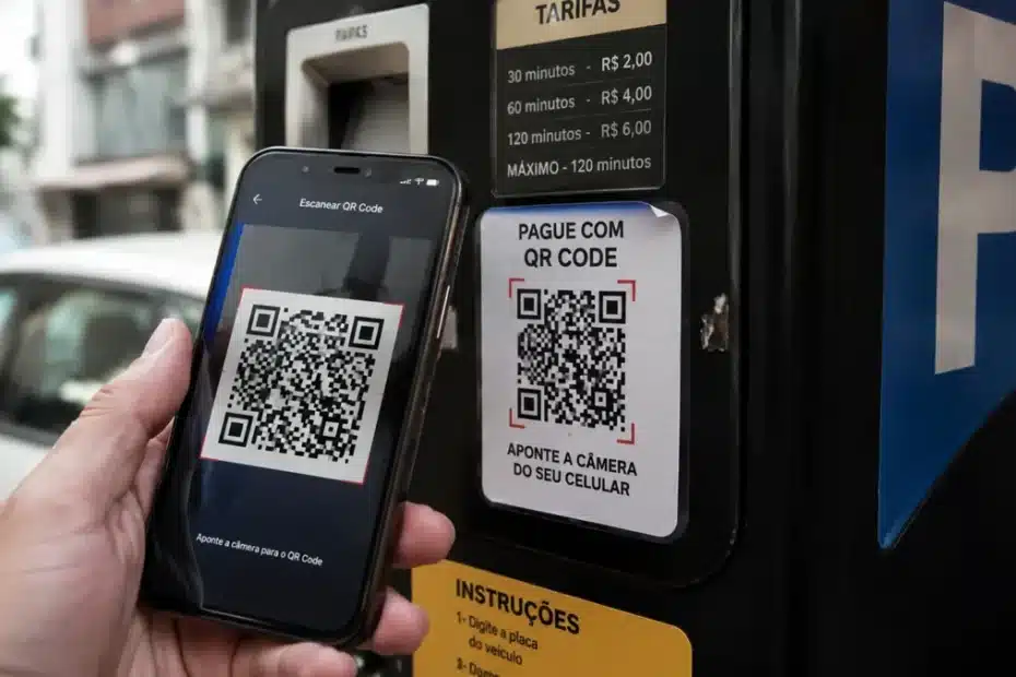 Mão de uma pessoa usando um smartphone para escanear um QR Code em um parquímetro, com o código mostrando sinais sutis de adulteração.