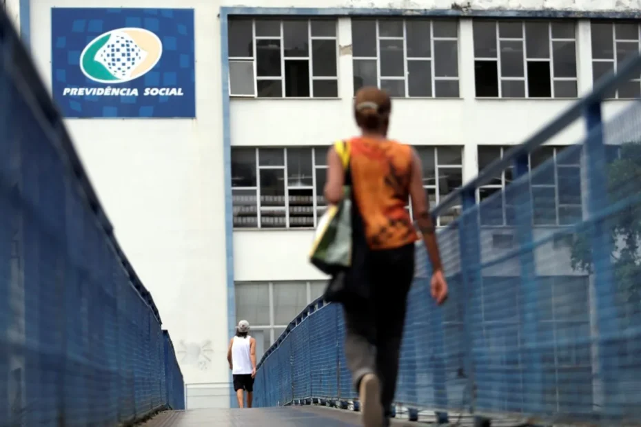 Pessoa preocupada segurando documentos do INSS, simbolizando a dificuldade em obter benefícios.