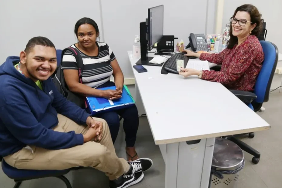 Pessoas aguardando atendimento ou consultando informações em uma agência do INSS, agendando serviços pelo Meu INSS ou Central 135.