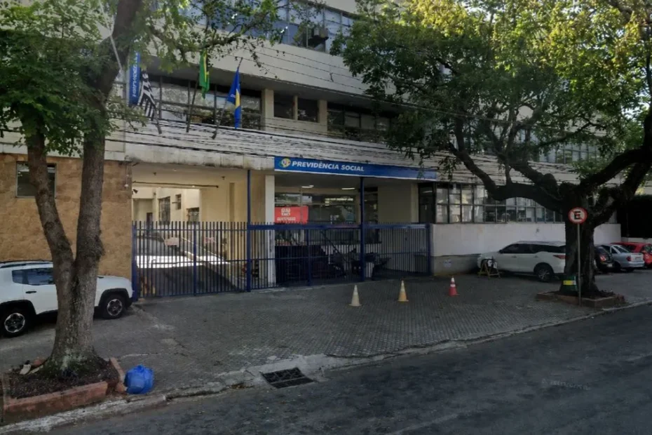 Pessoa analisando documentos do INSS em casa, com smartphone na mão, buscando informações sobre benefícios por incapacidade sem carência.