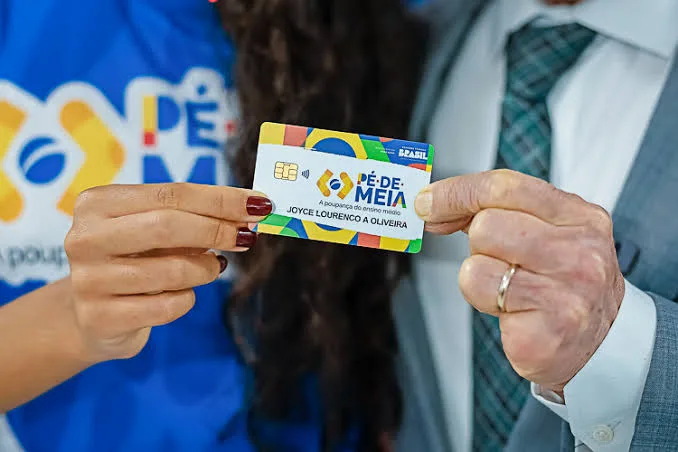 Jovem estudante consultando o calendário de pagamentos do programa Pé-de-Meia em um celular