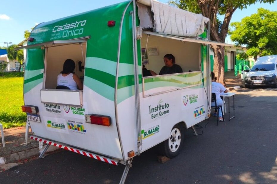 Pessoas sendo atendidas no trailer do CadÚnico itinerante em Sumaré, buscando informações sobre benefícios sociais.