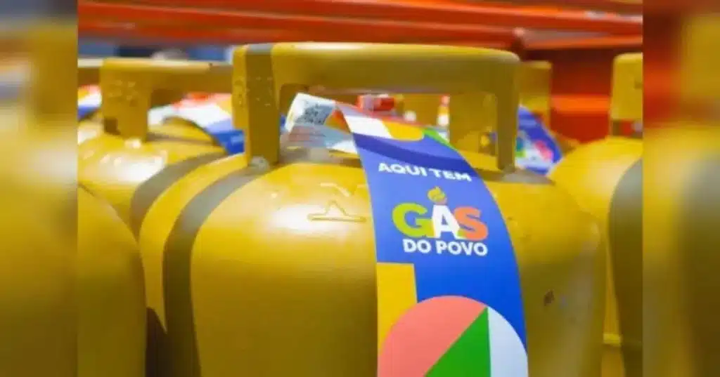 Mulher segurando celular com aplicativo de benefício social na cozinha