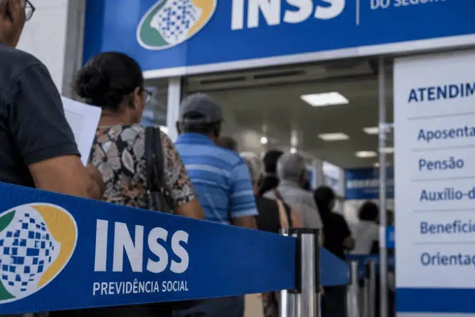 Fachada de agência do INSS com segurados aguardando atendimento.